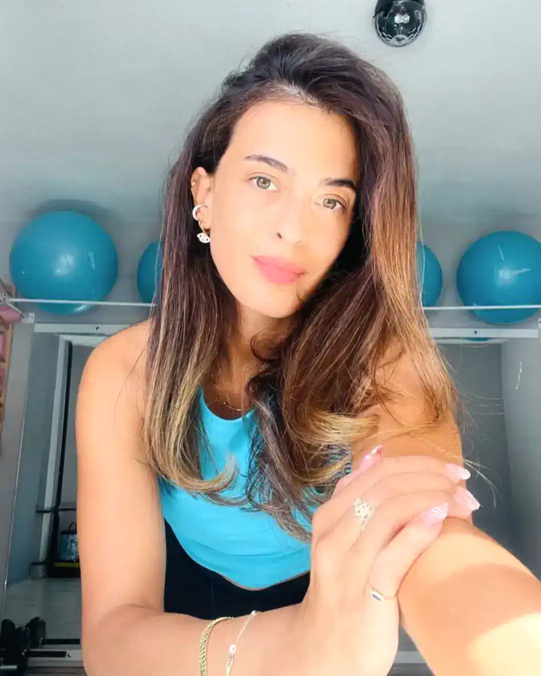 Pilates eğitmeni pozisyonunda, profesyonel duruşuyla stüdyoda